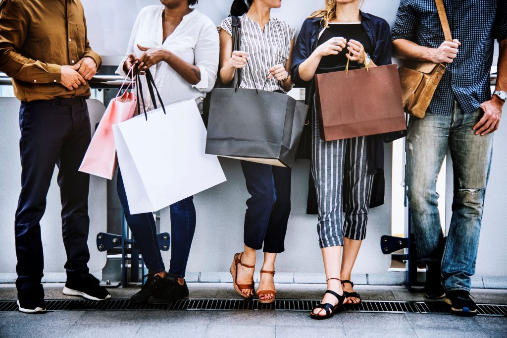 Grupo de personas con bolsas en la mano.